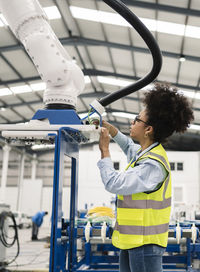 Engineer analyzing robotic arm machine in warehouse