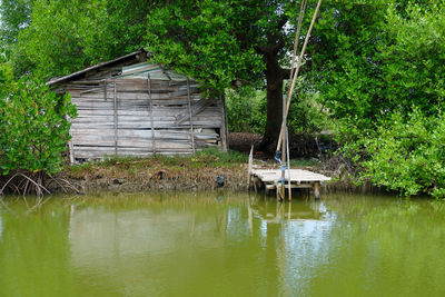 House by lake with trees in background