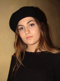 Portrait of beautiful young woman against wall