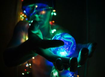 Shirtless man holding illuminated lights