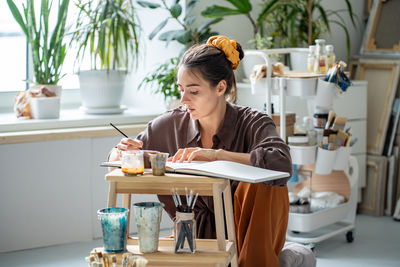 Young woman using mobile phone while sitting at home