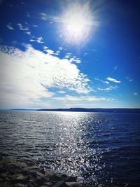 Scenic view of sea against bright sun