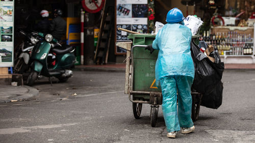 Rear view of a man walking on road