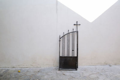 Black gate against wall in a greek orthodox churchyard 
