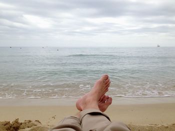 Low section of woman relaxing on beach