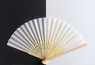 High angle view of hand fan on colored background