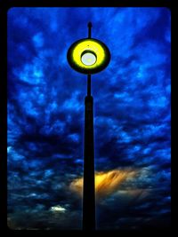 Low angle view of street light against cloudy sky