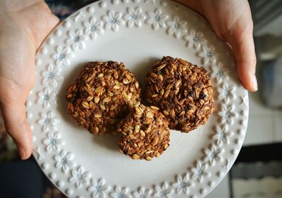 Close-up of hands holding plate of cookies