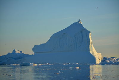 Scenic view of sea against clear sky with beautiful icebergs in the midnight sun ilulissat greenland