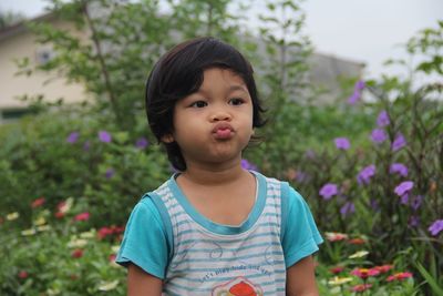 Portrait of cute girl standing against plants