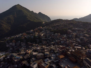 Aerial view of cityscape by mountains