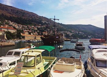 Boats moored at harbor against sky