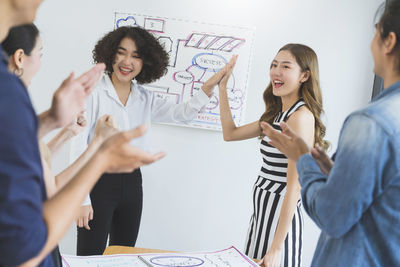 Woman holding a smiling while standing on table