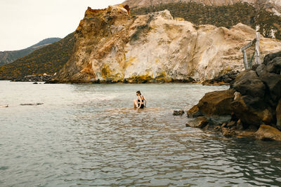 People on rock by sea