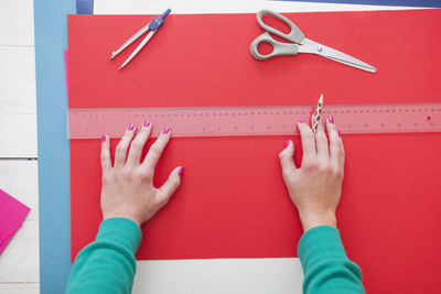 Cropped hands of woman with colorful papers on table