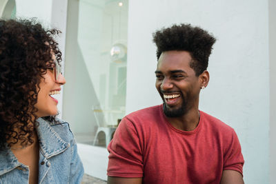 Cheerful friends laughing while sitting in cafe