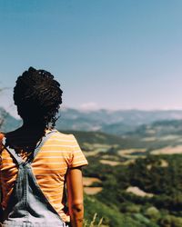 Rear view of woman standing against landscape