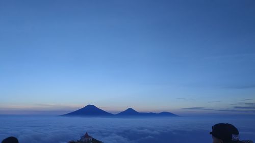 Rear view of man on mountain against clear sky