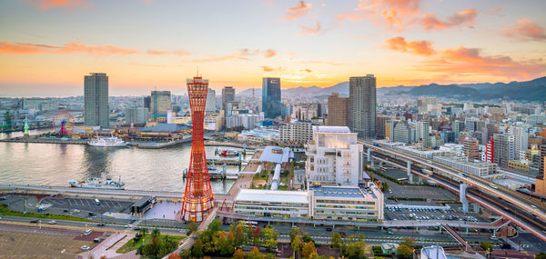 High angle view of river amidst buildings against sky during sunset