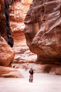 Woman walking against rock formations