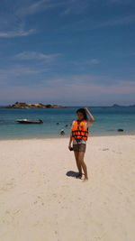 Portrait of mature woman standing at sandy beach