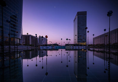 Reflection of illuminated buildings in city at night