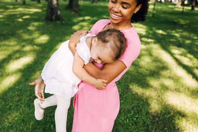 Smiling mother holding baby outdoors