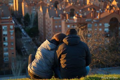 Rear view of couple walking in city during winter