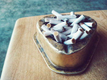 High angle view of cigarette butts in container