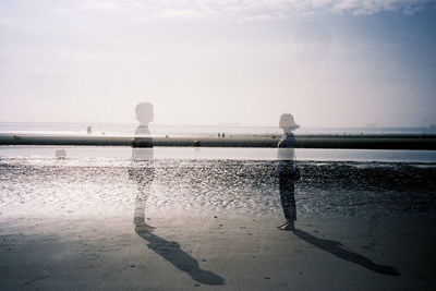 Double exposure of man and woman at beach