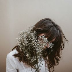 Portrait of woman against white wall