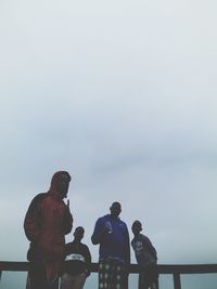 Rear view of people looking at sea against sky