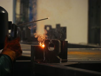 Cropped image of worker working on metal in factory