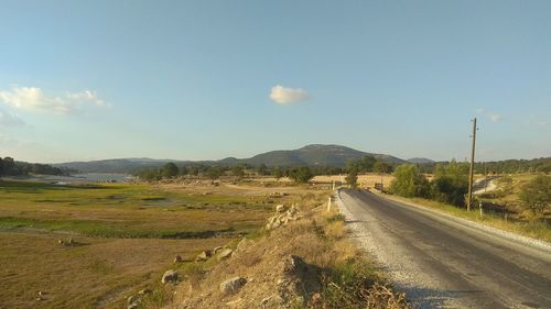 Road amidst field against sky