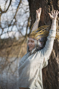Close up relieved woman with willow crown stretching arms up portrait picture