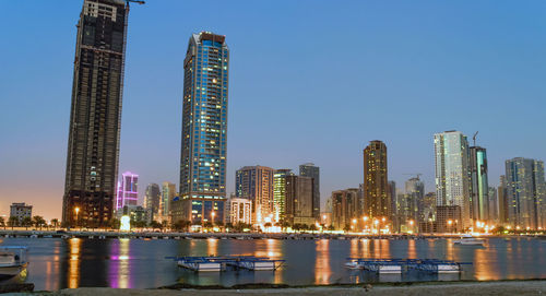 Illuminated skyscrapers against sky at night