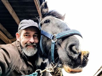 Portrait of smiling young man with horse