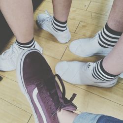 Low section of friends standing on hardwood floor