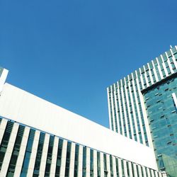 Low angle view of modern building against clear blue sky