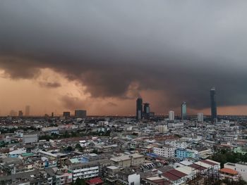 Aerial view of buildings in city against sky during sunset