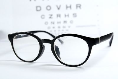 Close-up of eyeglasses on table against white background