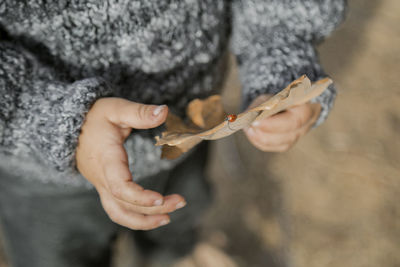 Midsection of woman holding leaf outdoors