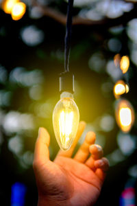 Close-up of hand holding light bulb