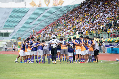 Players huddling in soccer stadium