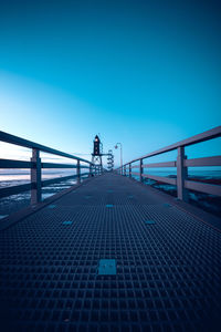 Bridge over footpath against clear blue sky