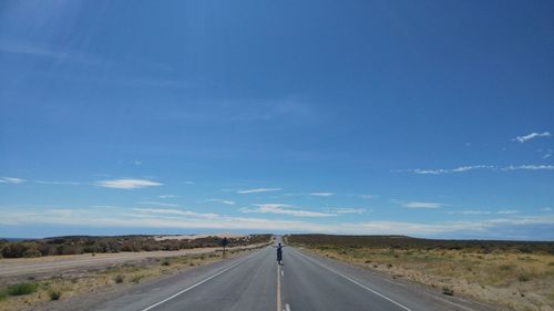 Empty road against blue sky