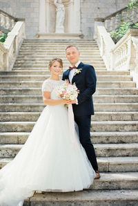 Midsection of bride holding bouquet