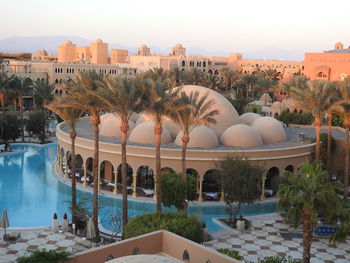 High angle view of palm trees and dome building by swimming pool