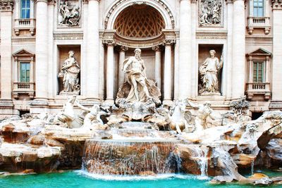 Statue of fountain in front of historical building