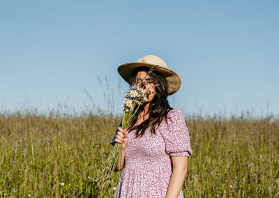 Woman standing on field against clear sky